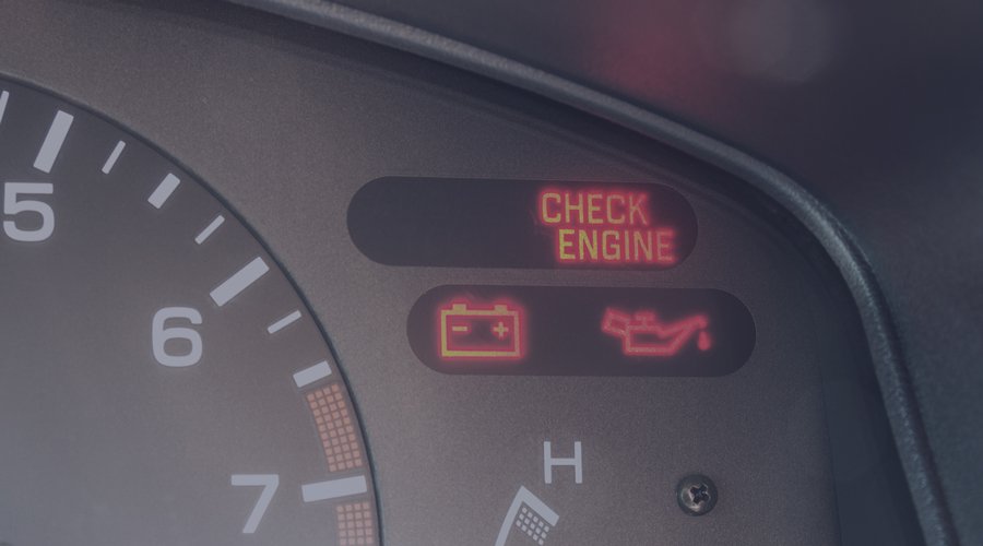 Car dashboard with check engine, battery, and oil lamps activated.