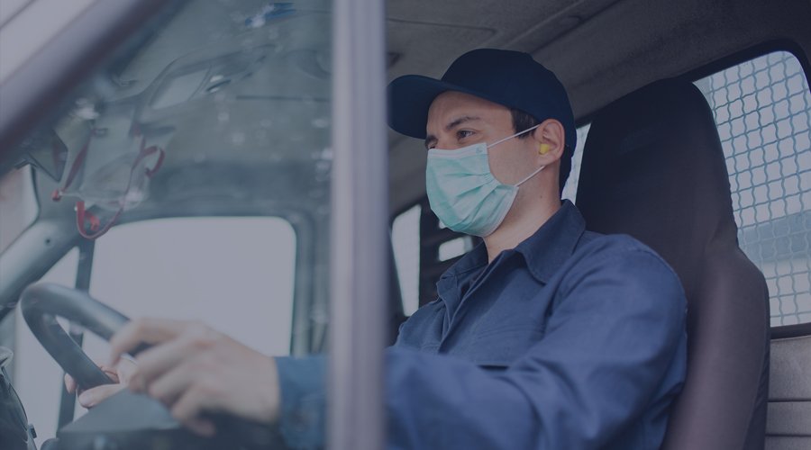 Employee wearing a mask while driving a vehicle.